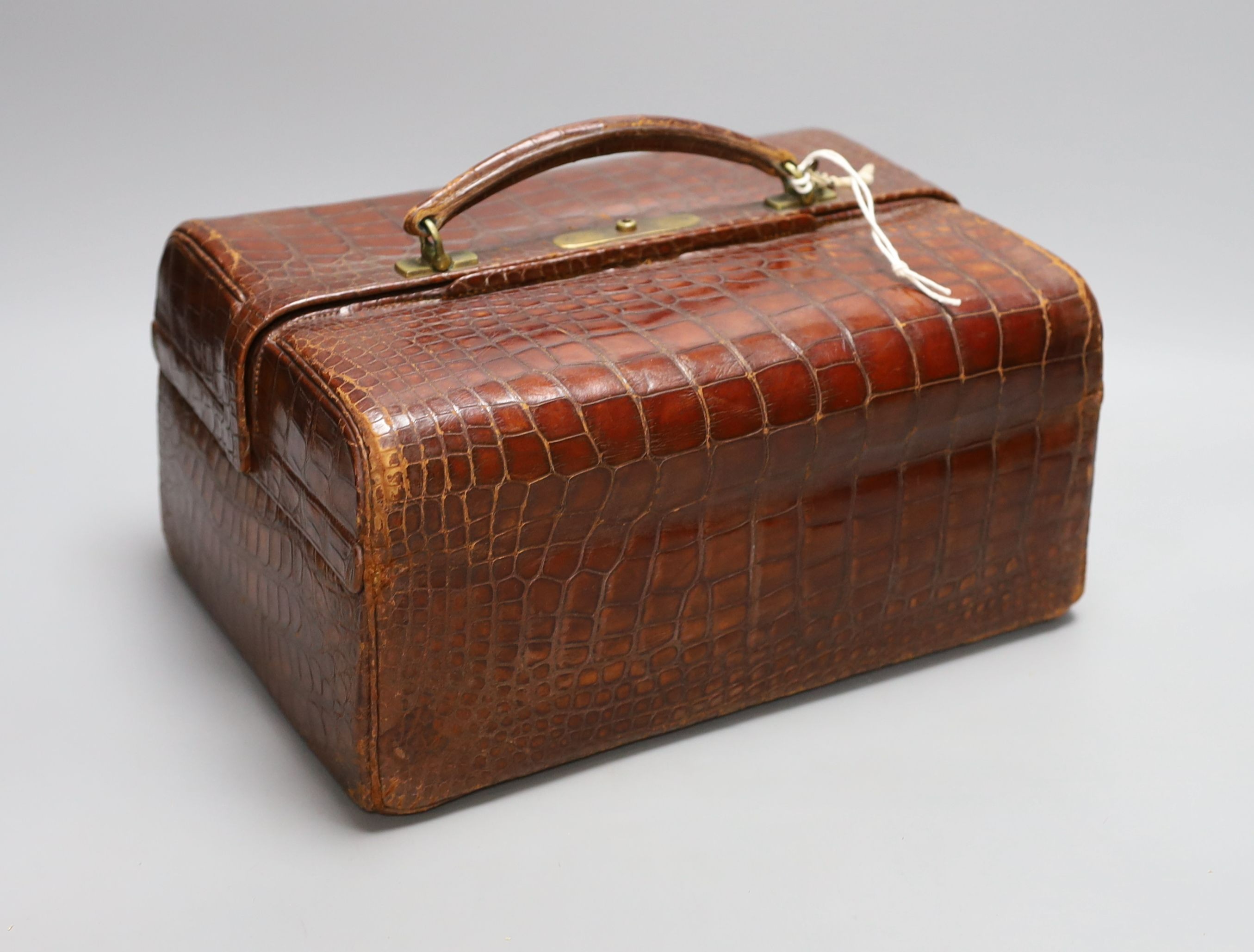 An early 20th century crocodile three tier travelling jewellery bag with key (lock a.f.) - 30cm long